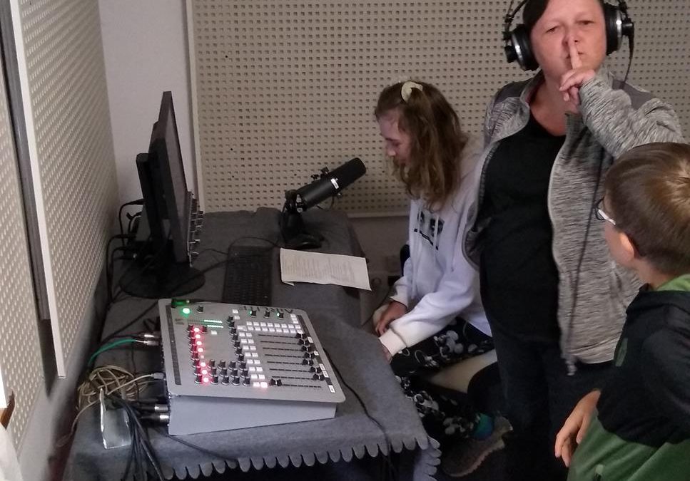 Realizatorka dzwięku i uczniowie w studiu radiowym
