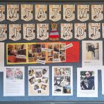 Na tablicy wielkimi literami napis Światowy Dzień Kota. Pod napisem umieszczone są w dwóch rzędach zdjęcia przedstawiające koty nauczycieli wraz z opisem pupili. Na tablicy widać dekoracyjne koty wykonane z kartonu i kolorowej włóczki.