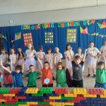 Uczniowie w pięknych strojach na tle dekoracji