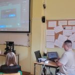 Nauczyciel prowadzi lekcję informatyki, pokazując obraz na projektorze