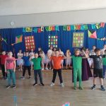 Uczniowie w pięknych strojach na tle dekoracji