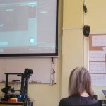 Nauczyciel prowadzi lekcję informatyki, pokazując obraz na projektorze