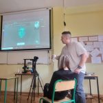 Nauczyciel prowadzi lekcję informatyki, pokazując obraz na projektorze