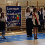 Uczniowie ubrani na galowo podczas uroczystości zakończenia roku szkolnego