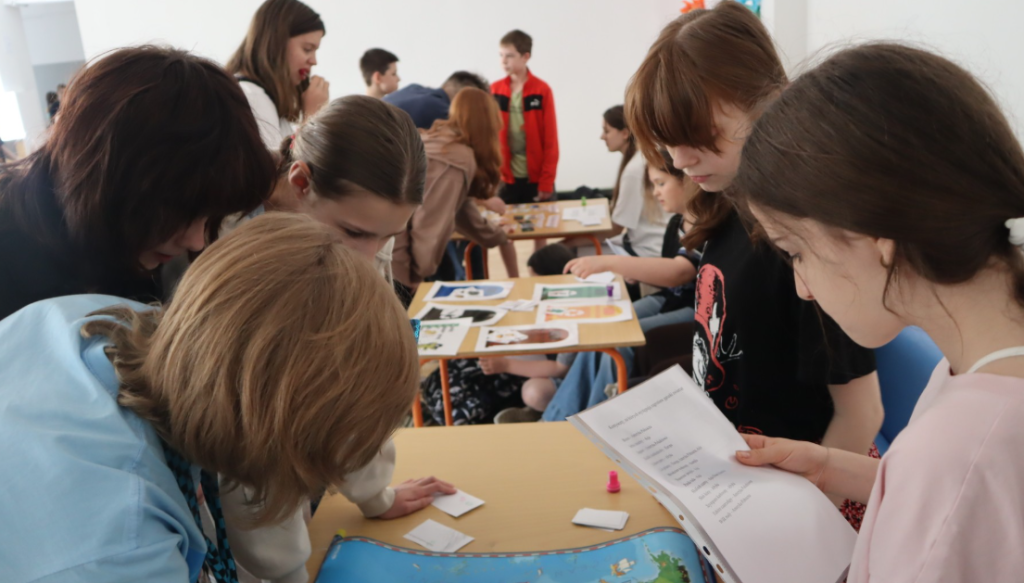 Uczniowie biorą udział w ekologicznych quizach na stanowiskach z zagadkami
