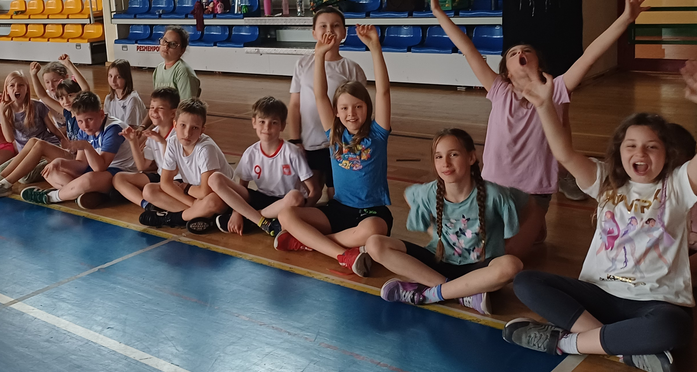 Dzieci z klas I-III w gimnastycznych strojach uczestniczą w zawodach i zabawach sportowych